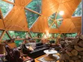 Wnętrze domu kopułowego z drewnianymi elementami i panoramicznymi oknami. Marzysz o takim domu? Sprawdź dom kopułowy pod klucz cena!