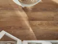Drewnopodobne panele laminowane czy winylowe na podłodze, z białymi meblami i fragmentem okrągłego stolika.