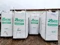 Pięć dużych worków z zielonym napisem "Leca KERAMZYT" i oznaczeniem "2 m³". Materiał budowlany, keramzytobeton, gotowy do użycia.