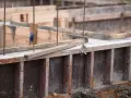 Drewniany szalunek czeka na beton. Widać zbrojenie i świeży beton.