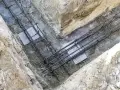Zbrojenie płyty fundamentowej w wykopie. Stalowe pręty tworzą siatkę, gotową na zalanie betonem.