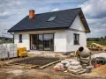 Budowa domu: bloczki, zbrojenie, cement i betoniarka na placu budowy.