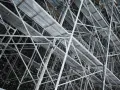 Skomplikowana konstrukcja rusztowania budowlanego z metalowymi platformami i wspornikami.