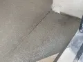 Dylatacja betonu na zewnątrz, widoczna linia podziału na świeżo wylanej nawierzchni, zapobiegająca pękaniu.
