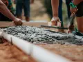 Pracownicy wygładzają świeży beton, dbając o jakość i cenę materiału.