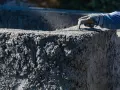 Ręka w rękawicy wygładza świeży beton C20/25. Sprawdź aktualną beton c20/25 cena za m3.
