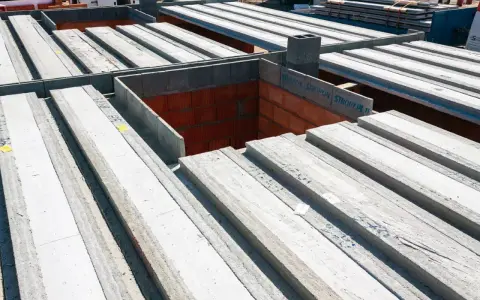 Strop panelowy smart cena za m2. Betonowe belki stropowe ułożone na budowie, gotowe do montażu.
