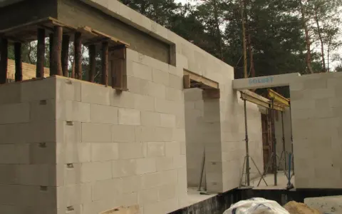 Budowa domu z bloczków betonowych. Widoczny maksymalny otwór bez nadproża, przygotowany do montażu okna lub drzwi.