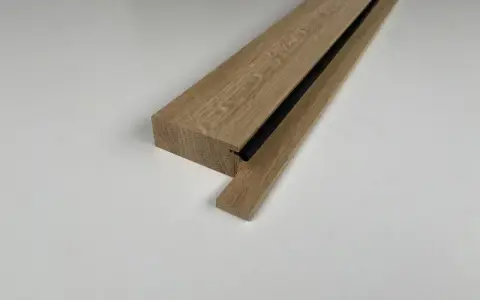 Drewniany element z czarną uszczelką, gotowy do montażu drzwi zewnętrznych jako próg.