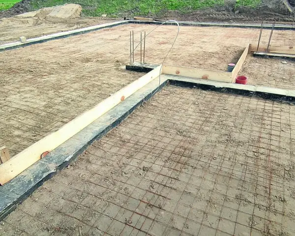 Przygotowanie pod fundamenty: siatka zbrojeniowa i szalunki czekają na odpowiedni beton na chudziaka.