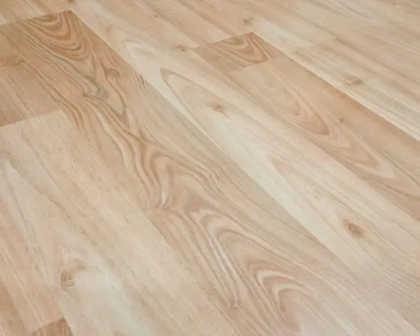 Jasne panele laminowane z widocznym usłojeniem. Dowiedz się, jak usunąć rysy z paneli domowym sposobem, by przywrócić im blask.