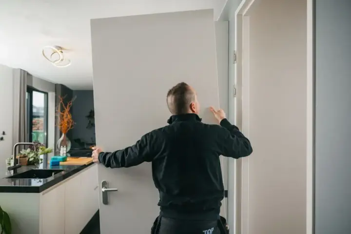 Fachowiec montuje drzwi wewnętrzne. Sprawdź, jaka jest montaż drzwi wewnętrznych cena i zamów usługę.