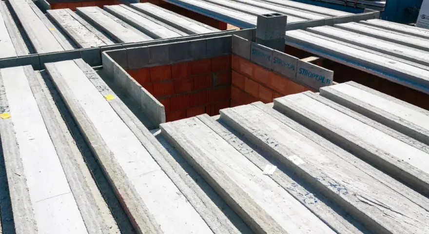 Strop panelowy smart cena za m2. Betonowe belki stropowe ułożone na budowie, gotowe do montażu.