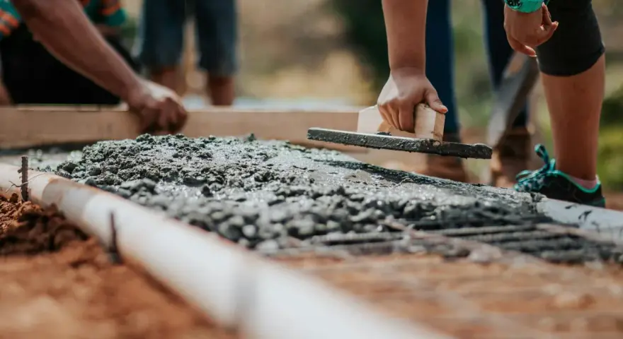 Pracownicy wygładzają świeży beton, dbając o jakość i cenę materiału.