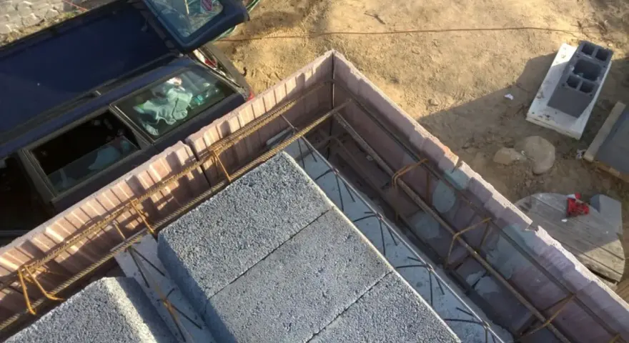 Budowa stropu Teriva: betonowe pustaki i zbrojenie czekają na zalanie. Obok stoi samochód.