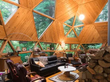 Wnętrze domu kopułowego z drewnianymi elementami i panoramicznymi oknami. Marzysz o takim domu? Sprawdź dom kopułowy pod klucz cena!