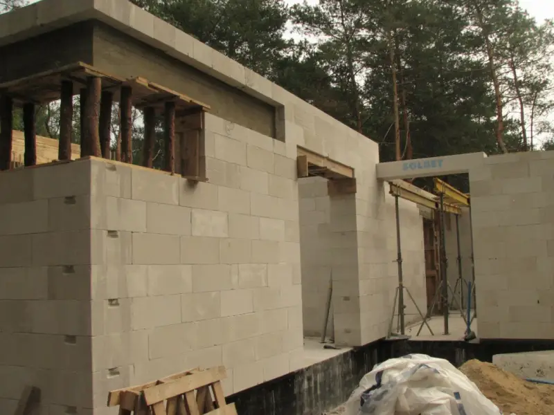 Budowa domu z bloczków betonowych. Widoczny maksymalny otwór bez nadproża, przygotowany do montażu okna lub drzwi.